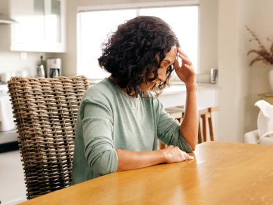 Woman sitting at a table experiencing a flashback